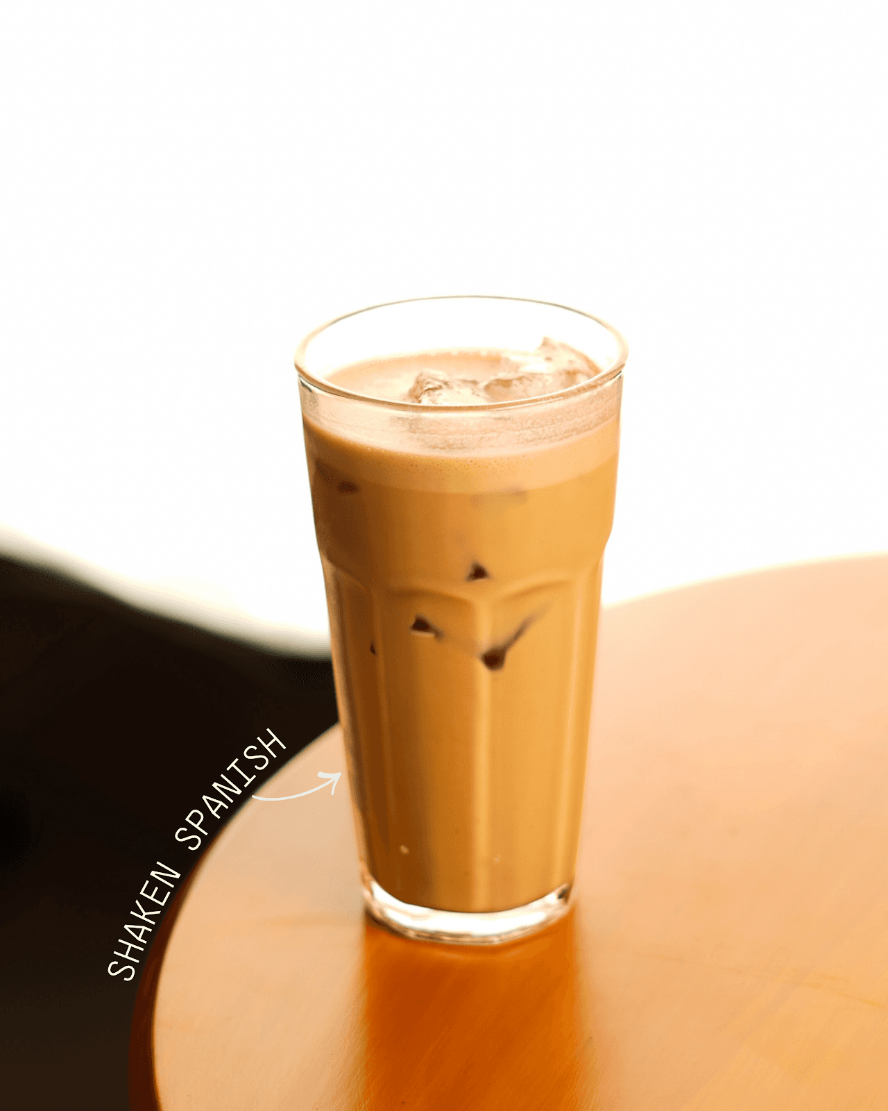 Iced shaken Spanish latte at 93 Brew — condensed milk and espresso shaken over ice in a tall glass